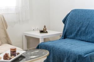 sala de estar con silla azul y mesa en Athenais Apartment, en Lixouri