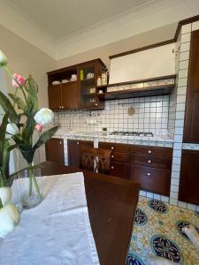 een keuken met een tafel met een vaas met bloemen bij La casa di Cinzia, Pompei/Vesuvio in Palma Campania