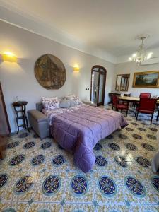 a bedroom with a purple bed and a dining room at La casa di Cinzia, Pompei/Vesuvio in Palma Campania