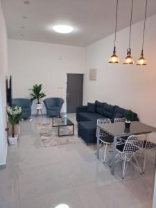 ein Wohnzimmer mit einem blauen Sofa und einem Tisch in der Unterkunft Puy Rambam's apartment Tiberias in Tiberias