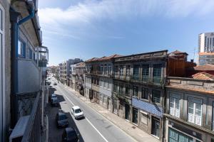 uitzicht op een straat met gebouwen en auto's bij Lovely Bonfim in Porto