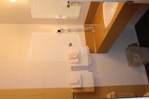 y baño con ducha y toallas blancas. en Pacific Rim Motel, en Ucluelet