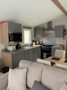 a living room with a couch and a kitchen at Kellysholidayhomes NEW Malton 3 bedroom Caravan in Weeley