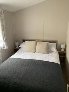 um quarto com uma cama com duas almofadas em Kellysholidayhomes NEW Malton 3 bedroom Caravan em Weeley