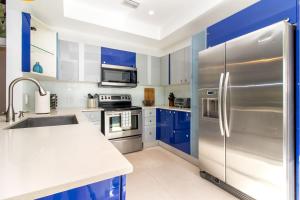 a kitchen with blue cabinets and a stainless steel refrigerator at Roami at Villa Bella in Miami