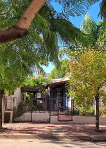 a house with a fence in front of a tree at Casa La Raquelita in Navarro
