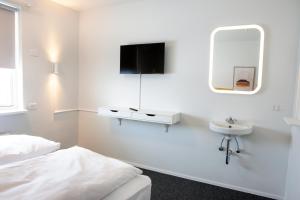 a white bedroom with a sink and a mirror at Eiðar - Hostel in Egilsstaðir +44 photos
