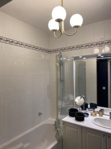 uma casa de banho com uma banheira, um lavatório e um chuveiro em Appartement Cosy, tout confort, à deux pas de la mer em Deauville