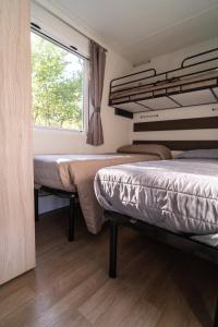 2 camas en una habitación con ventana en Romea Family Camping, en Casal Borsetti