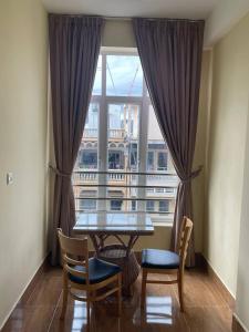 a table and chairs in front of a large window at BLUE SKY GUEST HOUSE in Phnom Penh