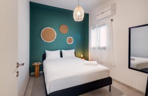 1 dormitorio con cama blanca y pared verde en Beach & Market Designed Duplex en Tel Aviv