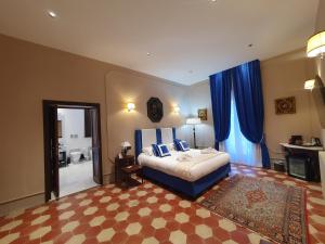 sypialnia z łóżkiem typu king-size i niebieskimi zasłonami w obiekcie Palazzo Papa Gregorio XVI w mieście Tivoli