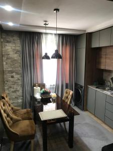 ein Wohnzimmer mit einem Tisch und Stühlen sowie eine Küche in der Unterkunft Sergeli 9 Resedens in Taschkent