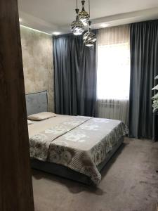 Schlafzimmer mit einem Bett und einem Fenster in der Unterkunft Sergeli 9 Resedens in Taschkent