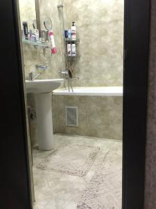 ein Badezimmer mit einem Waschbecken und einer Badewanne in der Unterkunft Sergeli 9 Resedens in Taschkent