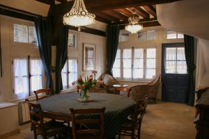 a dining room with a table and chairs and windows at La Maison des Corporations in Noyers