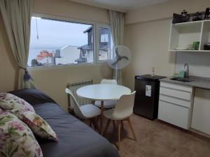 1 dormitorio con cama, mesa y ventana en Lofts Patagonia Mitre 3 en San Carlos de Bariloche