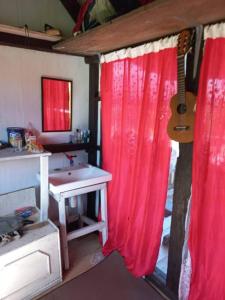 La salle de bains est pourvue d'un rideau rouge et d'une guitare. dans l'établissement Sada 360 homestay, à Sembalun Lawang