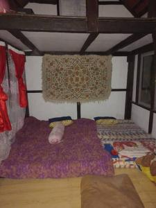 Zimmer mit einem Bett und einem Teppich an der Wand in der Unterkunft Sada 360 homestay in Sembalun Lawang