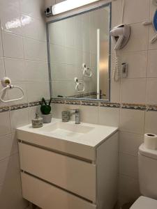 a bathroom with a sink and a mirror and a toilet at Lagos Apartment Sea View in Lagos