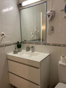 a bathroom with a sink and a mirror and a toilet at Lagos Apartment Ocean View in Lagos