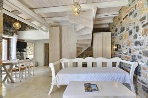 - une chambre avec un lit et un mur en pierre dans l'établissement Villas Palazzo Greco, Agia Galini, à Agia Galini