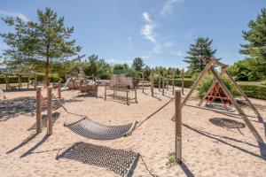 a playground with a swing set in the sand at Season Camper 700 in Löwenstein