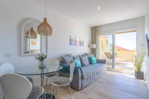 OleHolidays 535 Romana Playa con vistas al mar في مربلة: غرفة معيشة مع أريكة وطاولة