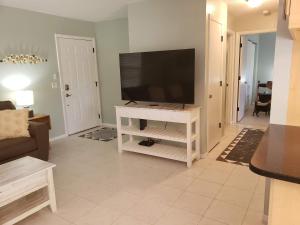 a living room with a flat screen tv on a white entertainment center at Venice Gardens, 2-Br Pet Friendly Home - Indra in Venice