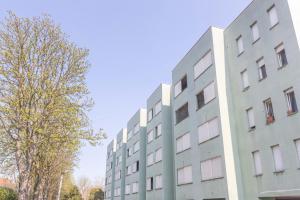 a tall white building next to a tree at Gobetti, Bologna by Short Holidays in Bologna +23 photos