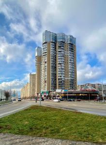 uma grande cidade com edifícios altos numa rua em Чарівна, простора квартира в 2хв від МВЦ, Лівобережна em Kiev