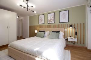um quarto com uma grande cama branca e 2 almofadas em Elegant flat in the city centre with two suite em Perugia
