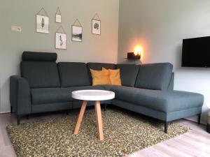 sala de estar con sofá azul y mesa en Veluwe Nature Home - 2-4 persons, en Otterlo