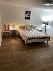 ein Schlafzimmer mit einem Bett, zwei Stühlen und einer Lampe in der Unterkunft Apartament cozy in Villerupt
