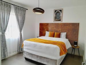 a bedroom with a large bed and a window at Inkazimulo Airbnb in Estcourt