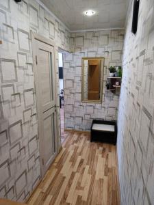 un pasillo con una pared de piedra blanca y una puerta en Квартира посуточно, en Shchūchīnsk