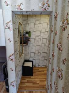 Habitación con pared, espejo y mesa. en Квартира посуточно, en Shchūchīnsk