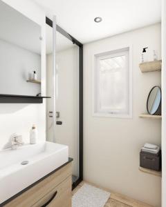 een badkamer met een wastafel en een spiegel bij Mobile Home OuiReves 344 facing the Mediterranean in Lattes
