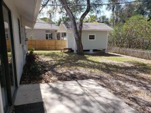 a house with a tree and a bench in the yard at Venice Gardens, 2-Br Pet Friendly Home - Indra in Venice