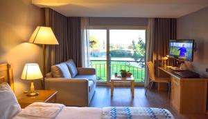 een hotelkamer met een bed en een woonkamer met een balkon bij Denizatı Plus Hotel in Istanbul