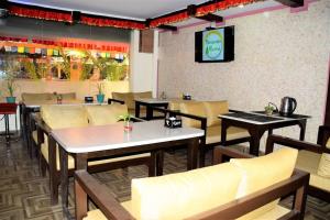 a restaurant with tables and chairs and a tv at Studio Family apartment Thamel, green-hospitality in Kathmandu
