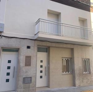 een gebouw met twee witte deuren en een balkon bij Casa Cullerer in Amposta