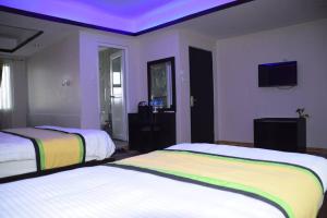a bedroom with two beds and a purple ceiling at Studio Family apartment Thamel, green-hospitality in Kathmandu
