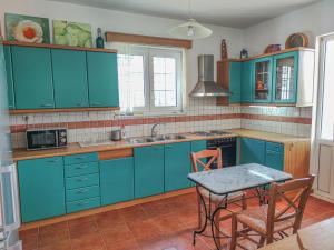 una cucina con armadi blu e tavolo con sedie di Minos's House a Kathiana