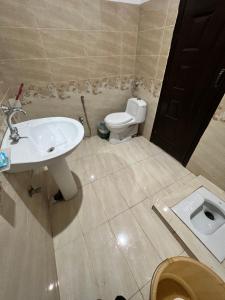 a bathroom with a white sink and a toilet at Al Atif Guest House in Islamabad