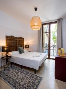 a bedroom with a large white bed and a window at Mesones 54 in Granada
