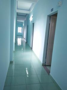 a hallway with blue walls and a tile floor at Nhà nghỉ Quốc Khánh in Hue