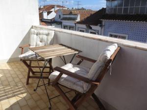 a pair of chairs and a table on a balcony at Aveiro Luz in Aveiro