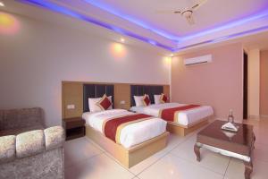 ein Hotelzimmer mit 2 Betten und einem Sofa in der Unterkunft Hotel Del Inn Near IGI Airport in Neu-Delhi