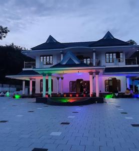 una casa grande con luces delante en Gilead Holliday, en Tāmarakulam